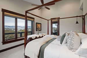 Carpeted bedroom featuring a mountain view, ceiling fan, and a high ceiling