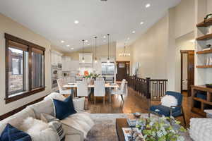 Living area featuring dark wood-type flooring, recessed lighting, and vaulted ceiling