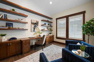 Office featuring built in study area, dark wood-type flooring, lofted ceiling, and recessed lighting