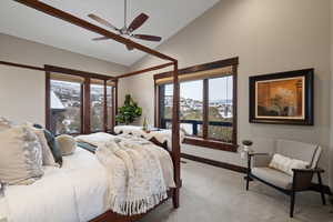 Carpeted bedroom with a mountain view, lofted ceiling, and a ceiling fan