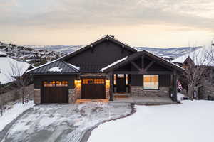 View of front of home featuring a garage, a standing seam roof, a mountain view, driveway, and covered porch