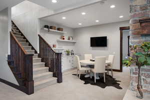 Dining area featuring wet bar, light carpet, and recessed lighting