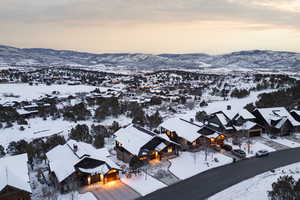 Snowy aerial view featuring a mountain view and a residential view