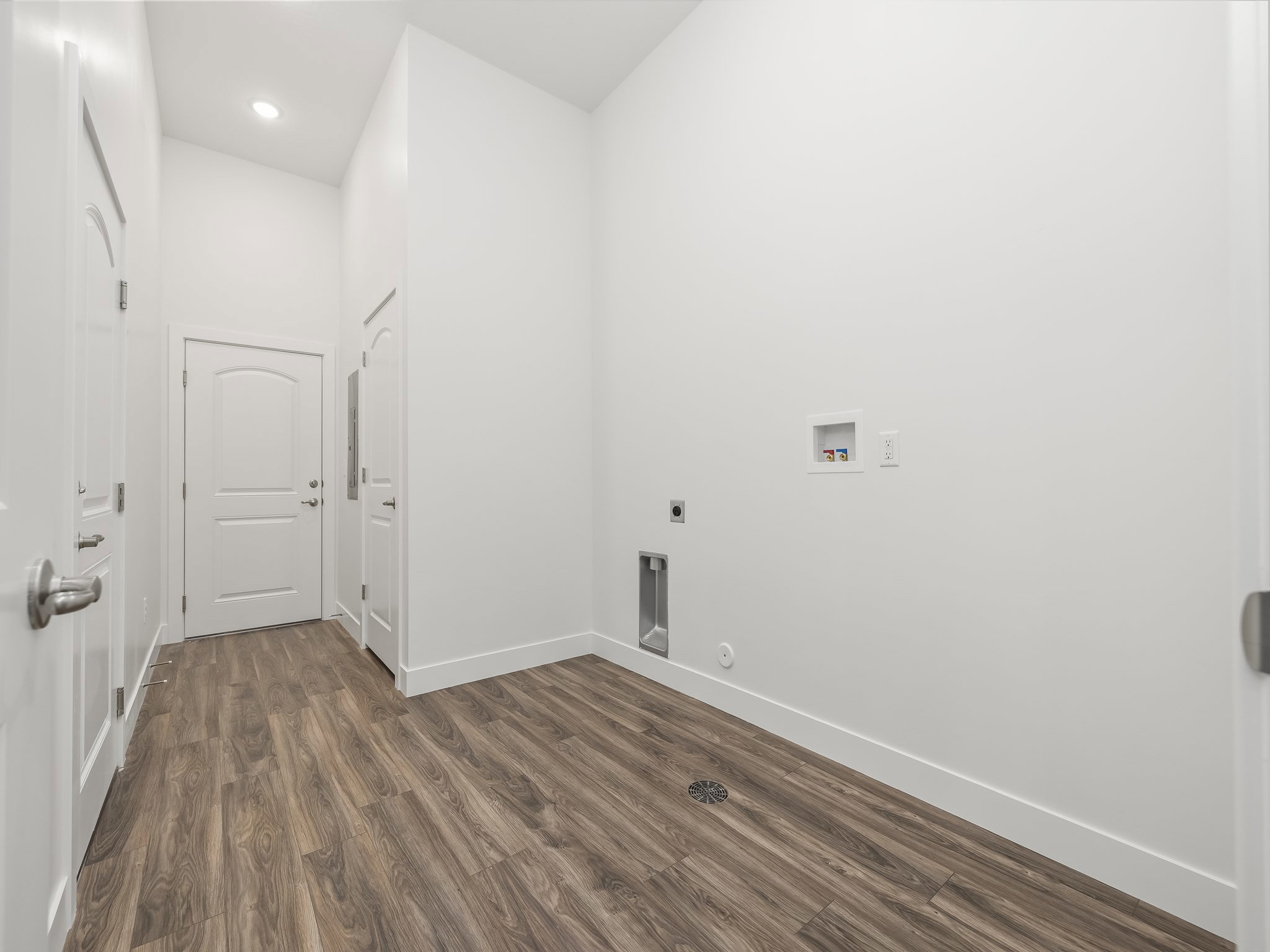 Spacious laundry room with extra storage and access to garage and community breezeway.