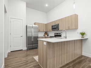 Kitchen with Midtone cabinets, tile backsplash, pendant lighting and quartz counters. *Fridge not included