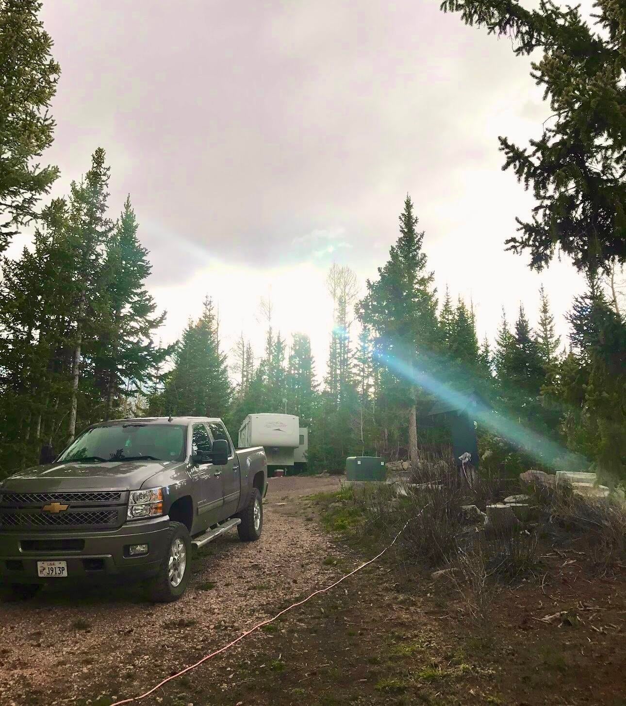 View of parking featuring view of wooded area