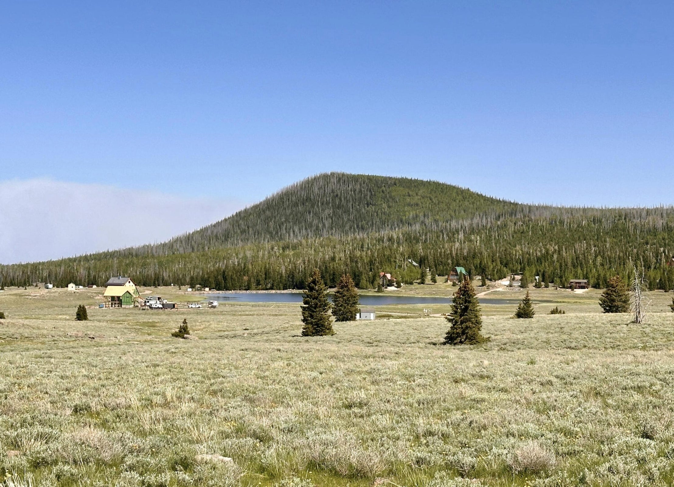 View of mountain background with a large body of water and a forest