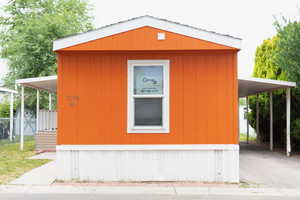 View of home's exterior featuring a carport, a porch, and driveway