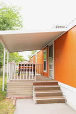 View of exterior entry featuring a wooden deck
