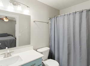 Full bathroom featuring vanity, a shower with shower curtain, connected bathroom, and a textured ceiling