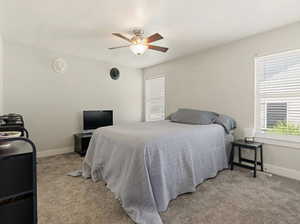 Bedroom with light carpet, a textured ceiling, and a ceiling fan