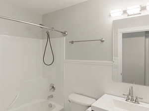 Full bath featuring a wainscoted wall, vanity, and shower / bath combination
