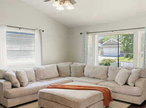 Living area with a ceiling fan and vaulted ceiling