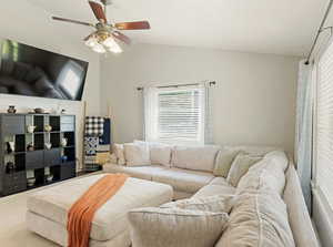 Carpeted living area with lofted ceiling and ceiling fan