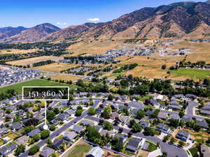 Aerial overview of property's location featuring nearby suburban area, a mountainous background, and property parcel outlined