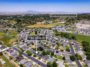 Aerial view of property and surrounding area featuring nearby suburban area and a mountainous background