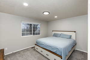 Bedroom with carpet flooring, a textured ceiling, and recessed lighting