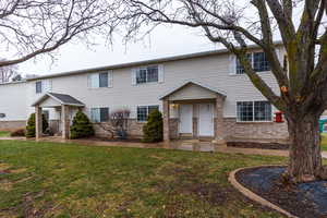 View of front of property with brick siding and a front lawn