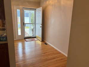 Doorway to outside featuring wood finished floors and baseboards