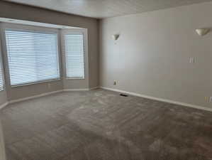 Empty room with carpet and a textured ceiling
