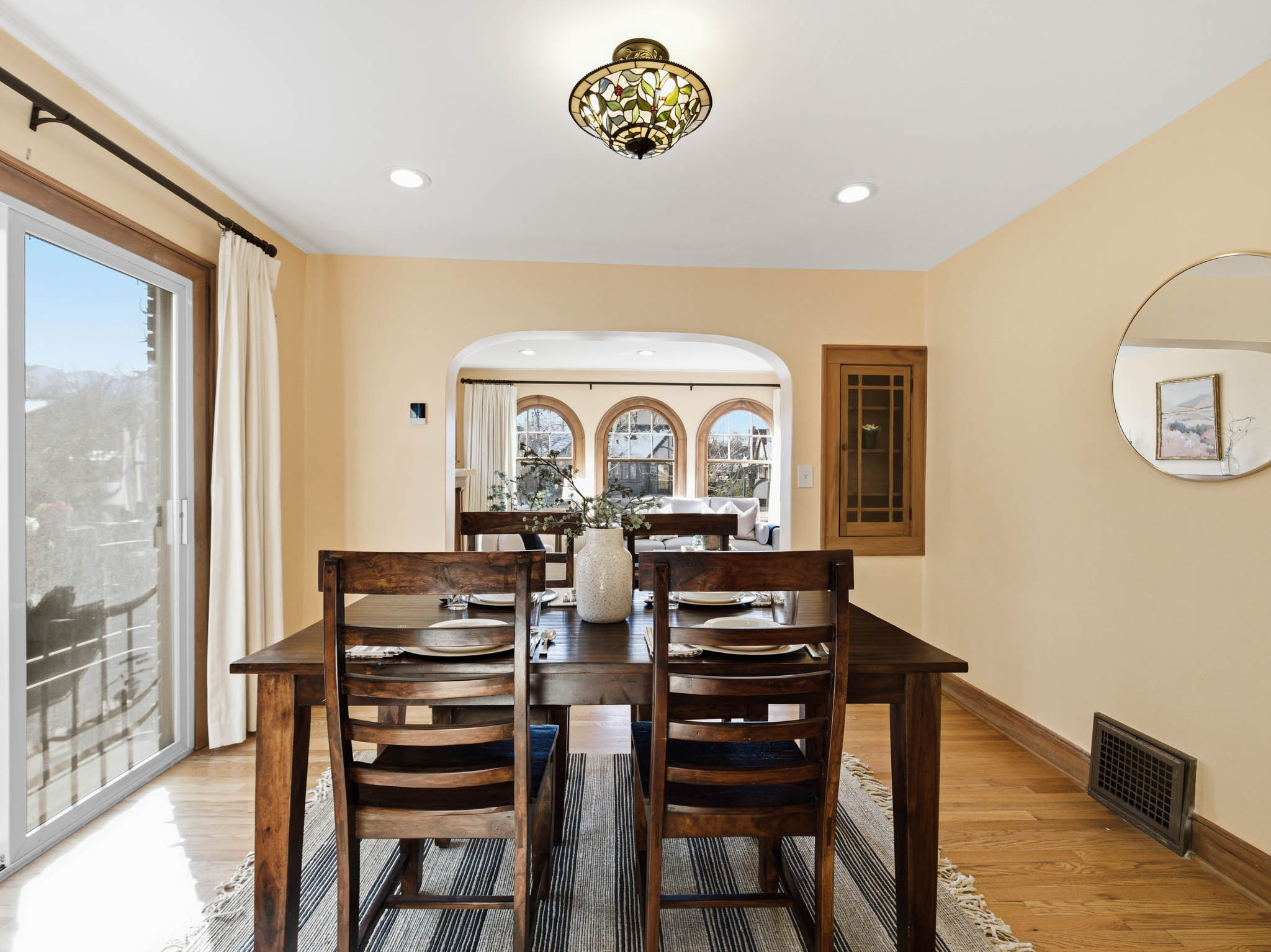 Dining space featuring light wood-type flooring, recessed lighting, and arched walkways