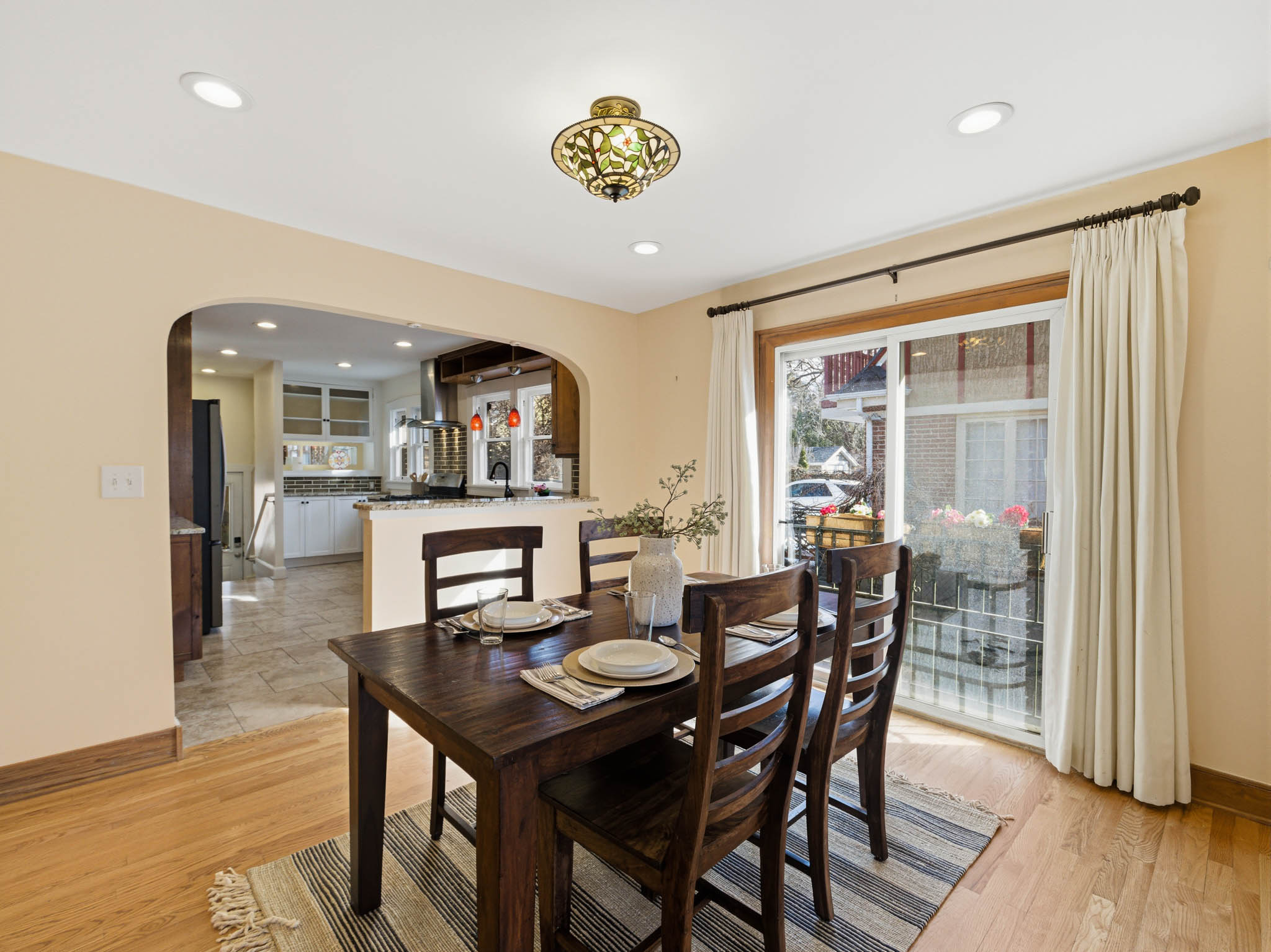 Dining room featuring arched walkways, light wood finished floors, and recessed lighting