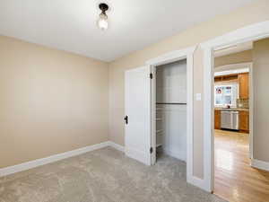 Unfurnished bedroom with a closet and light carpet