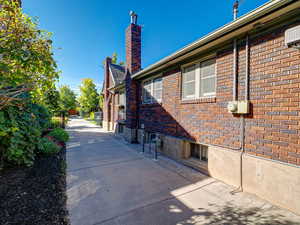 View of side of home with brick siding and a chimney