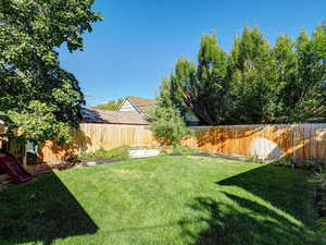 Fenced backyard with a playground