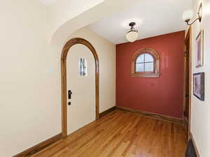 Entrance foyer featuring light wood-type flooring and arched walkways