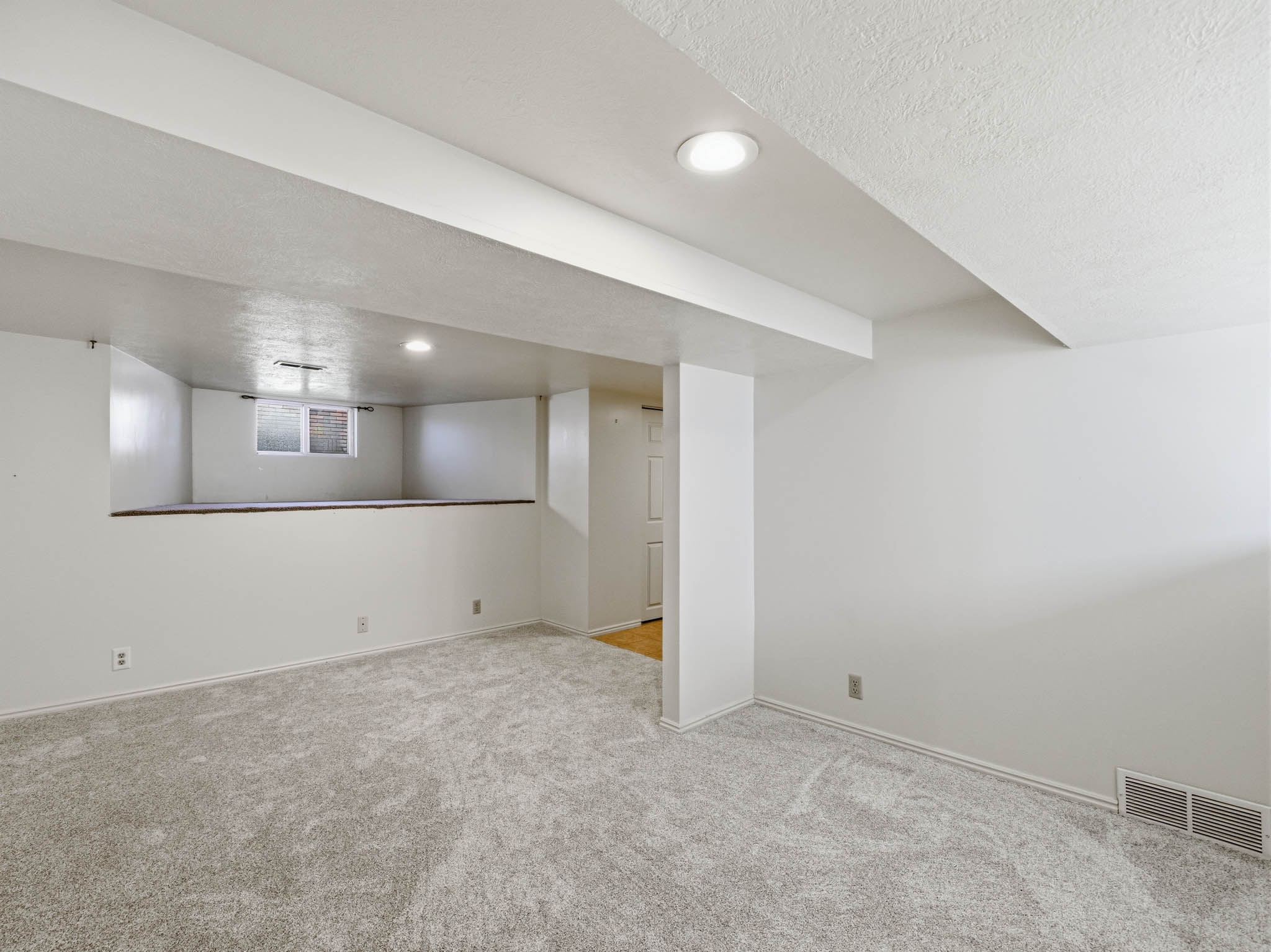 Basement with carpet, a textured ceiling, and recessed lighting