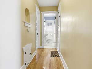 Hall with wood-type flooring and baseboards