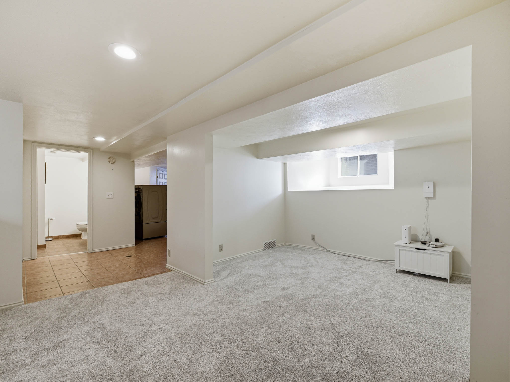 Finished basement with light carpet and recessed lighting