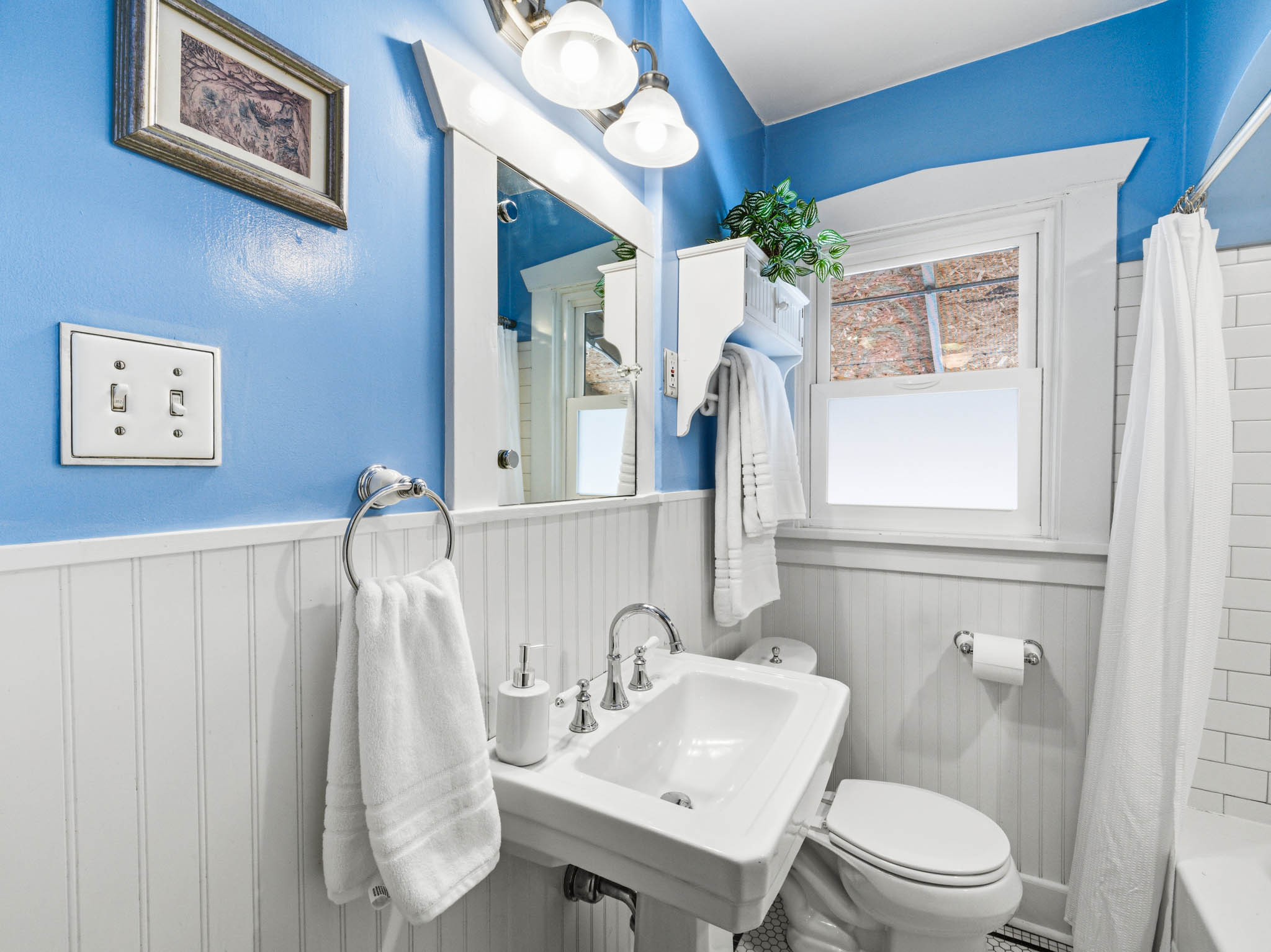Bathroom featuring a wainscoted wall and shower / tub combo