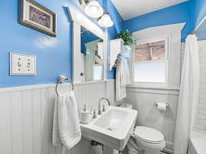 Bathroom featuring a wainscoted wall and shower / tub combo