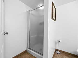 Bathroom featuring a stall shower and dark tile patterned floors