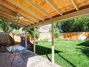 Fenced backyard featuring a patio and ceiling fan