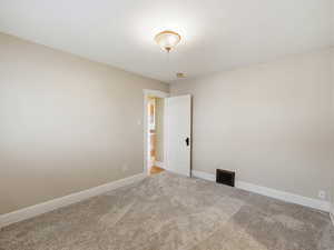 Unfurnished room with baseboards and carpet