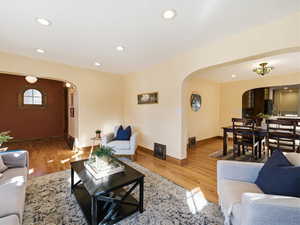 Living room featuring recessed lighting, arched walkways, and light wood-type flooring