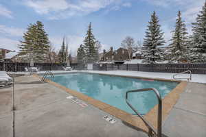 Community pool with a patio