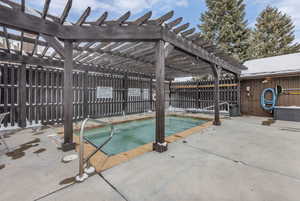 View of pool featuring a hot tub, patio surround, and a pergola