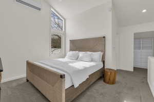Bedroom with vaulted ceiling and carpet flooring