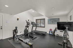 Workout room with a textured ceiling and recessed lighting