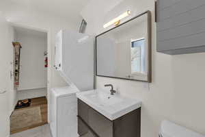 Bathroom with vanity and stacked washer and dryer
