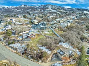 Snowy aerial view featuring a mountain view and a residential view