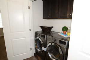 Laundry area featuring separate washer and dryer and cabinet space