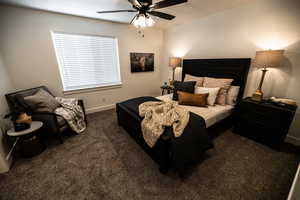 Bedroom with dark carpet and a ceiling fan