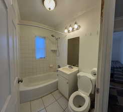 Bathroom with vanity, light tile patterned flooring, washtub / shower combination, and ornamental molding