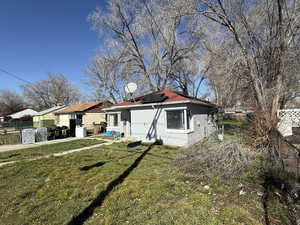 View of front of home with stucco siding and solar panels