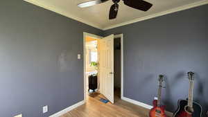 Bedroom with ornamental molding, light wood finished floors, and a ceiling fan